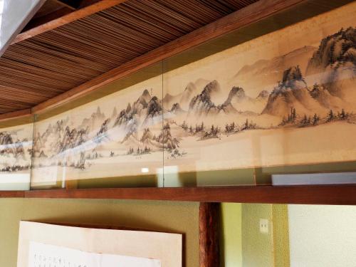 a painting of mountains on the wall of a room at Seikiro Ryokan Historical Museum Hotel in Miyazu