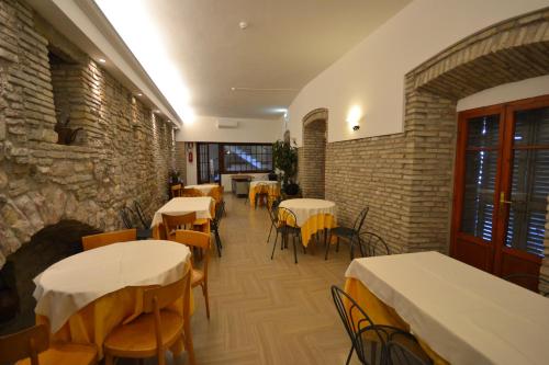 un ristorante con tavoli e sedie e un muro di mattoni di Hotel Il Castello ad Assisi