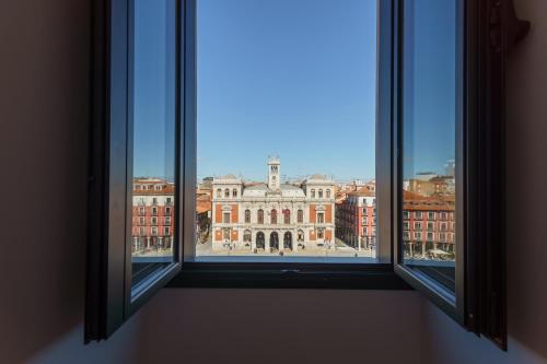 a view of a large building from an open window at Edificio 13 by Plaza Mayor Apartamentos in Valladolid