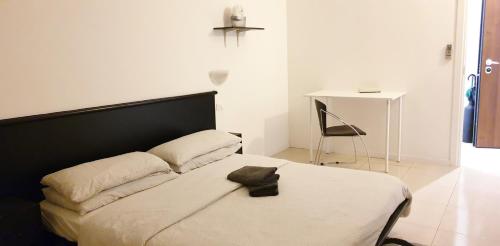 una camera con letto con testiera nera e sedia di Michelangelo 81 2Bdr Apartment 75m2 a Milano