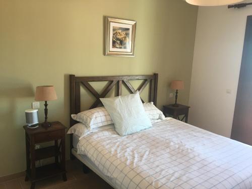 a bedroom with a bed with two night stands and two lamps at Casares Village Bed & Breakfast in Casares