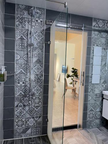 a shower in a bathroom with a glass door at Sundaze in Hengchun