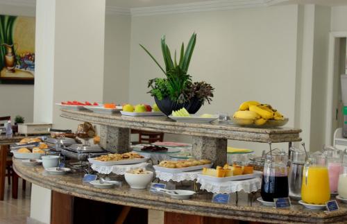um buffet com muitos tipos diferentes de comida em uma mesa em Hotel Itajaí Tur - Itajaí Navegantes em Itajaí