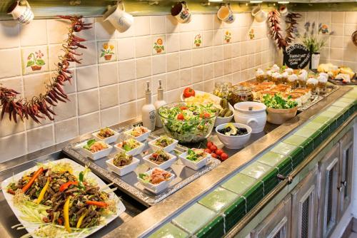 a buffet line with many different dishes of food at Hotel Piroska in Bük