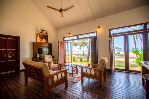 Sala de estar con mesa y sillas y vistas al océano en Malabar Ocean Front Resort And Spa, Bekal, en Nīleshwar