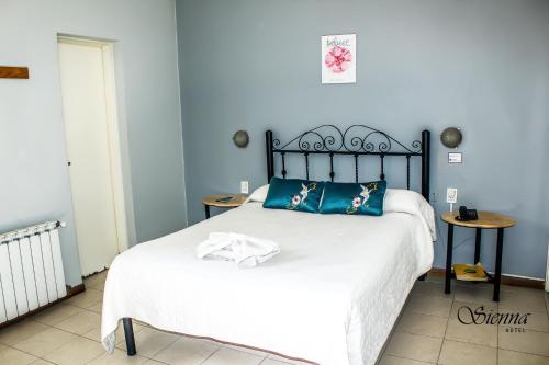 a bedroom with a large bed with blue walls at Hotel Sienna in Mendoza