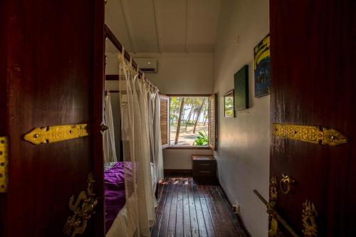 a hallway with a room with a bed and a window at Malabar Ocean Front Resort And Spa, Bekal in Nīleshwar