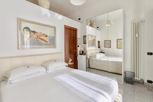 a white bedroom with a bed and a bathroom at Aiello Suites Milan in Milan