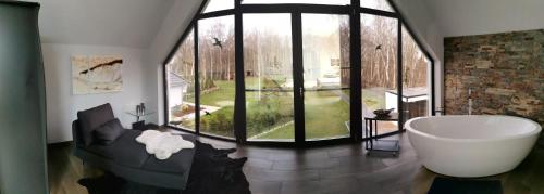 sala de estar con bañera y ventana grande en Uns Langhus, en Fuhlendorf