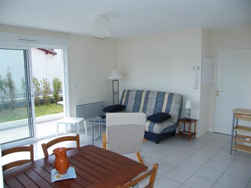 un salon avec une table et un canapé dans l'établissement Appartement Rez-De-Chaussee 4 Personnes Face Au Port De Peche- Residence Le Magellan, à Capbreton