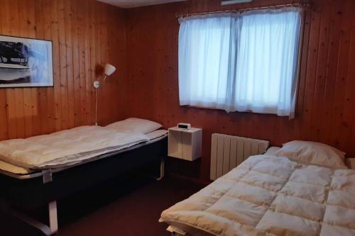 deux lits jumeaux dans une chambre avec fenêtre dans l'établissement Chalet Danois, à Gérardmer