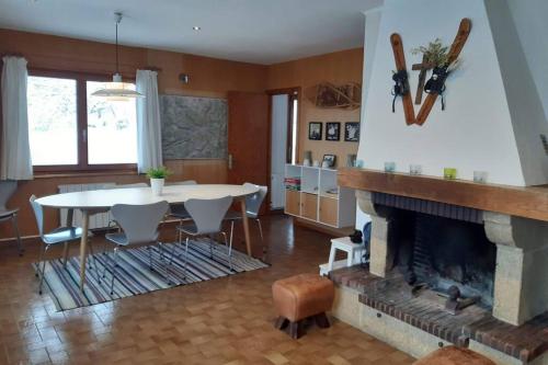 un salon avec une table et une cheminée dans l'établissement Chalet Danois, à Gérardmer