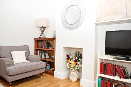 a living room with a chair and a tv at Little Lane in Alverstoke