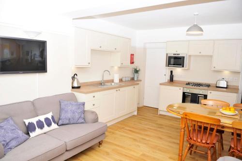 a kitchen and living room with a couch and a table at Little Lane in Alverstoke