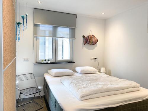 um quarto com uma cama e uma janela em Vakantiehuis Zee, Bos & Duin Zoutelande ZO02 em Zoutelande