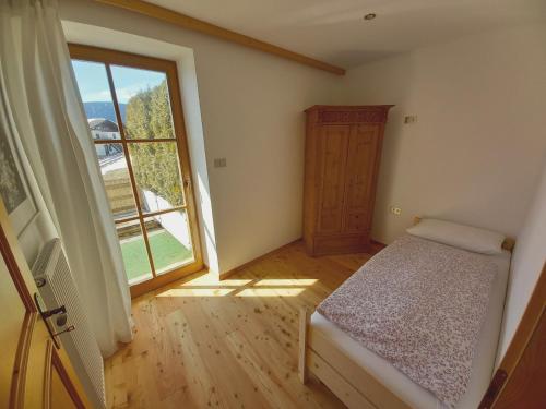 1 dormitorio con cama y ventana grande en Apartment Panorama Val di Non, en San Felice