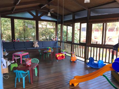 a large room with chairs and tables and windows at Amoreiras Hotel Pousada in Maresias