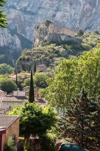 une colline avec un château au sommet d'une montagne dans l'établissement La Figuiere Fontaine de Vaucluse, à Fontaine-de-Vaucluse