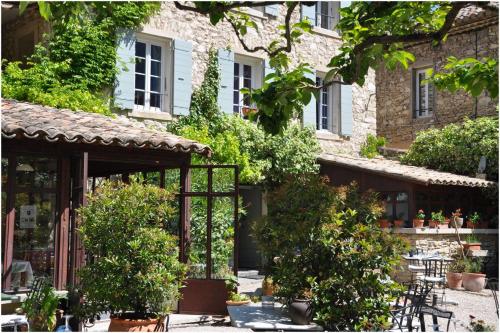 a courtyard of a building with chairs and trees at La Figuiere Fontaine de Vaucluse in Fontaine-de-Vaucluse