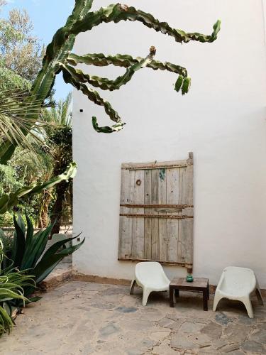 a patio with two chairs and a table and a door at Dar al Hossoun in Taroudant