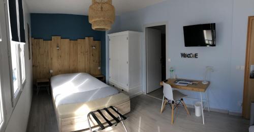 a bedroom with a bed and a table and a desk at Le Relais Du Lac in Hossegor