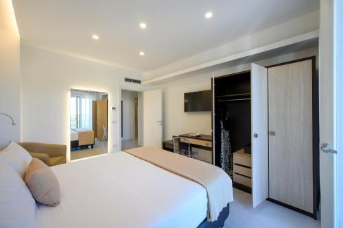 1 dormitorio con cama blanca y escritorio en Angiolina Apartments, en Sorrento