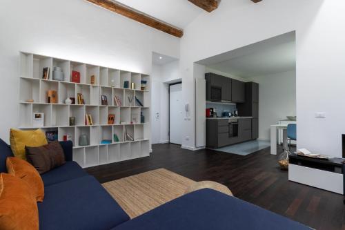 Una sala de estar con un sofá azul y una cocina. en Arela, en Verona