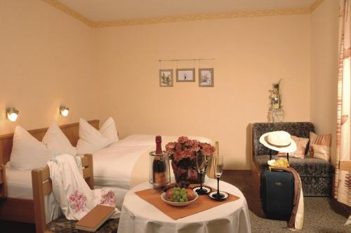 um quarto de hotel com uma cama e uma mesa com flores em Landhaus-Pension Zum Waffenschmied em Brand