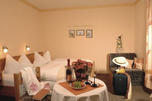 ブラントにあるLandhaus-Pension Zum Waffenschmiedのベッドと花のテーブルが備わるホテルルームです。