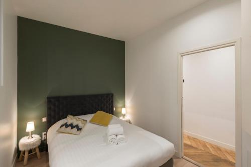 - une chambre dotée d'un lit avec un mur vert dans l'établissement Le Confident - Grand T2 au coeur de Lyon, à Lyon