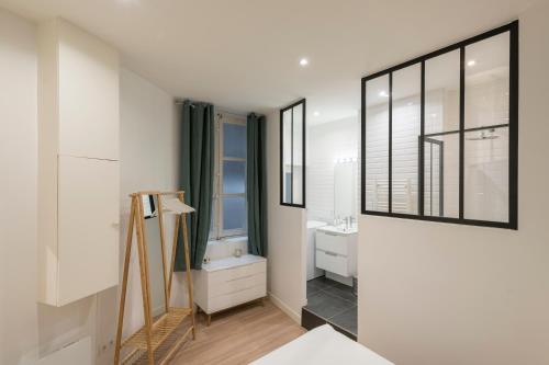 un bagno bianco con due lavandini e uno specchio di Le Confident - Grand T2 au coeur de Lyon a Lione