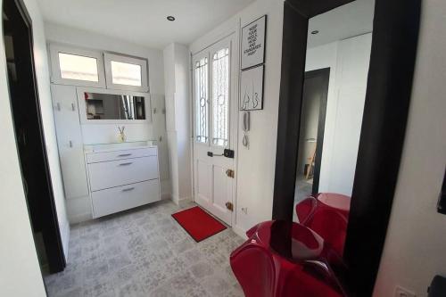 ein Wohnzimmer mit roten Stühlen und eine Küche in der Unterkunft Très jolie bas de maison en centre ville, parking, Wi-Fi, Netflix in Cannes