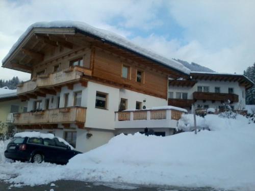 a building with a car parked in the snow at Haus Roland in Zell am Ziller