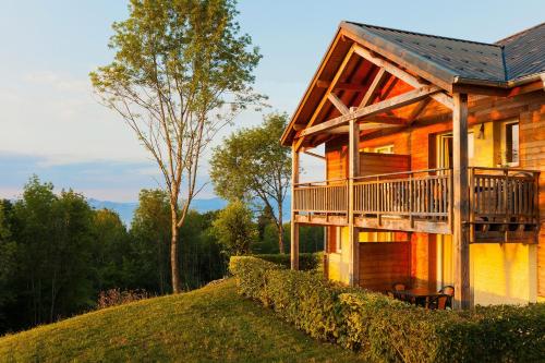 ein Holzhaus mit Balkon auf einem Hügel in der Unterkunft Garden & City Evian - Lugrin in Lugrin