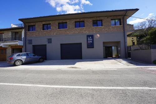 a building with a car parked in front of it at Larrion Hostal - Ostatua in Larrión