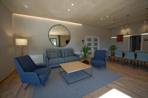 a waiting room with blue chairs and a table and a mirror at Larrion Hostal - Ostatua in Larrión