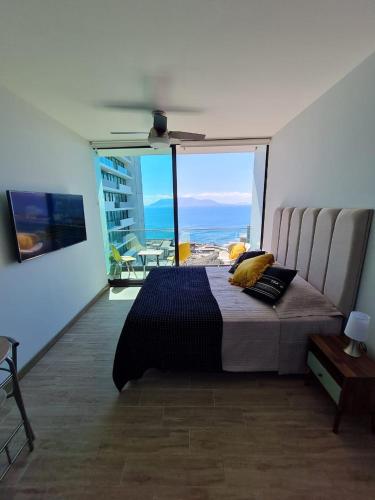 a bedroom with a bed with a view of the ocean at Departamento costado mall plaza, Balmaceda Antofagasta in Antofagasta