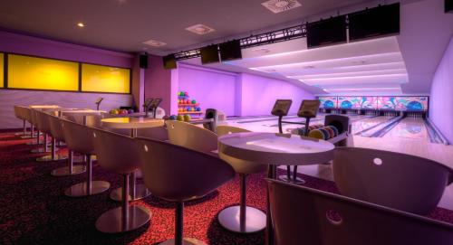 a bowling alley with tables and bowling lanes at Bohinj Eco Hotel in Bohinj