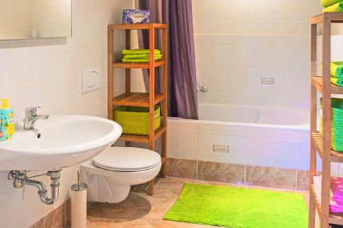 łazienka z umywalką, toaletą i wanną w obiekcie Gästehaus Lehmann w mieście Schönfeld