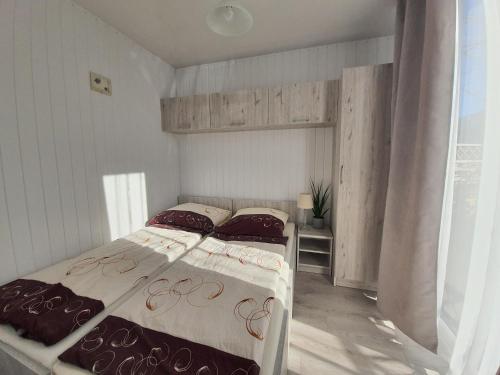 a bedroom with two beds and a window at Domki PrzystańTu in Jastarnia