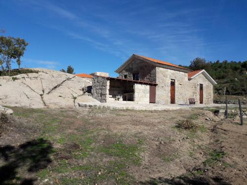 una pequeña casa de piedra en la cima de una colina en Quinta de S. Cipriano, en Resende