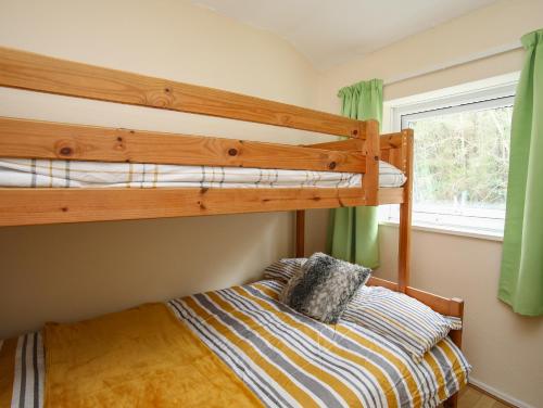 a bedroom with two bunk beds and a window at Eirlys in Caernarfon