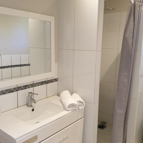 une salle de bain blanche avec un lavabo et un miroir dans l'établissement Villa Ribba 10 pers piscine 5 min plage en voiture, à Porto-Vecchio