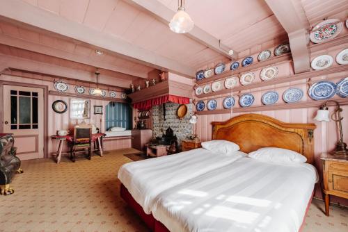 Un dormitorio con una cama y platos en la pared en Hotel Spaander BW Signature Collection, en Volendam