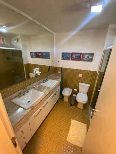 a bathroom with two sinks and a toilet in it at Maresias flat mata azul in Maresias