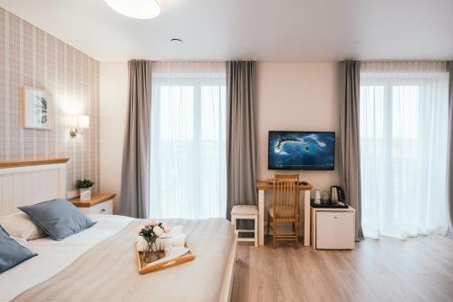 a hotel room with a bed and a table with flowers on it at J14A I Rooms & Apartments AUTOMATED SELF CHECK-IN in Vilnius