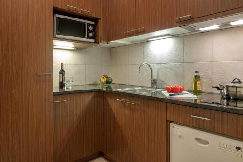 a kitchen with a sink and a microwave at Citadines Saint-Germain-des-Prés Paris in Paris