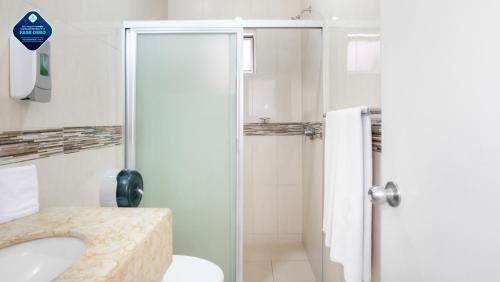 y baño con ducha, aseo y lavamanos. en Hotel Maioris Guadalajara, en Guadalajara