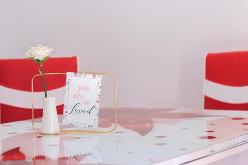 a table with a vase with a flower and a sign at Stars & Mountain Apartment in Buşteni