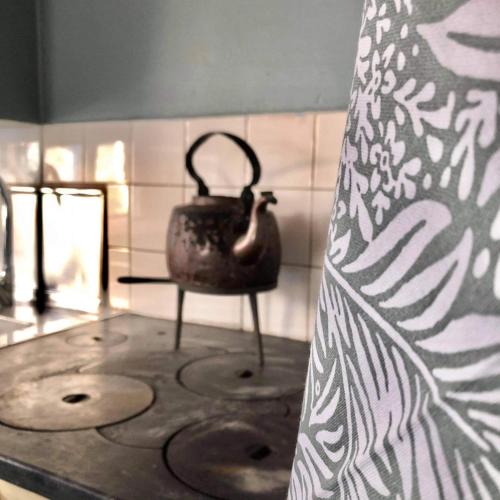 a tea kettle sitting on a table in a room at Almas gård in Ullared